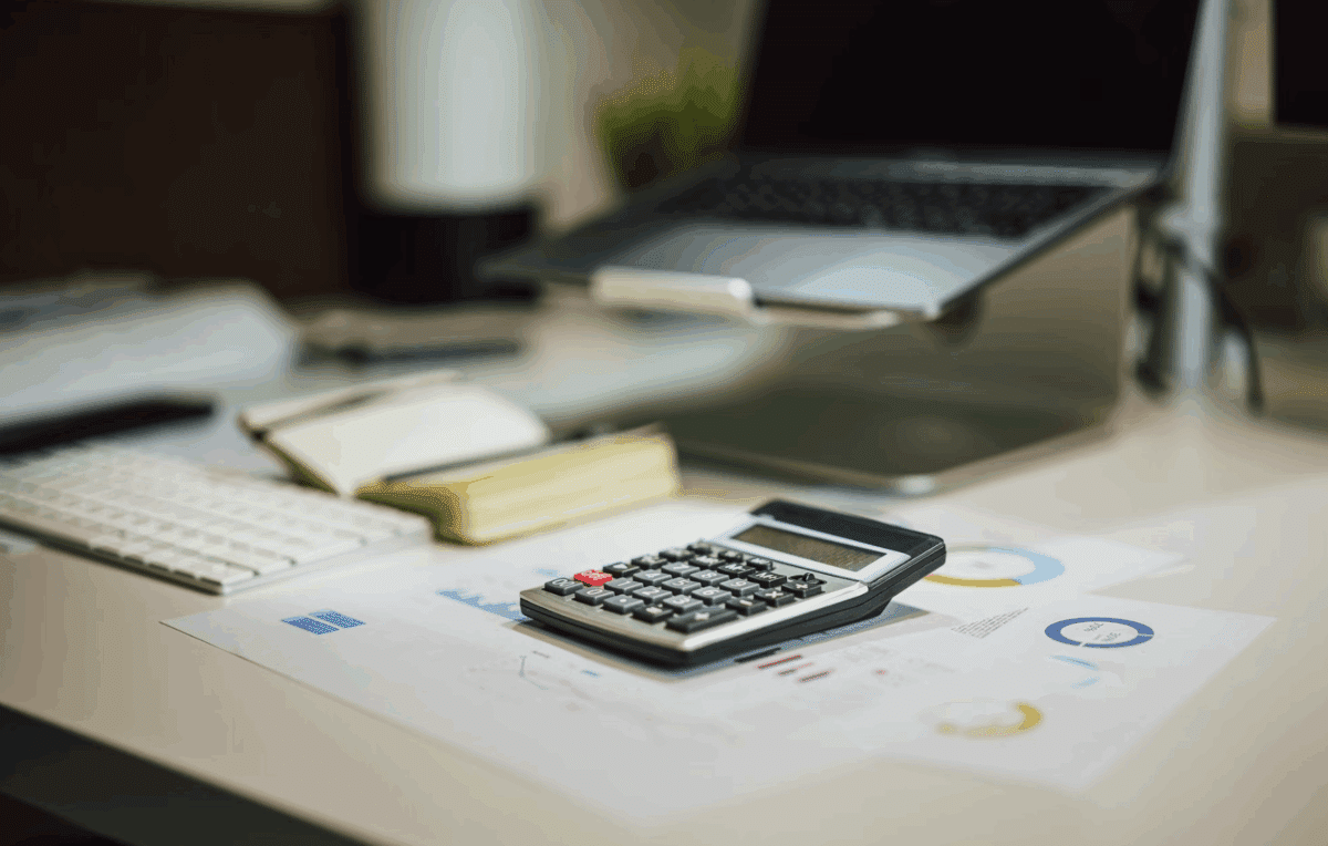 Un bureau couvert de documents avec une calculatrice
