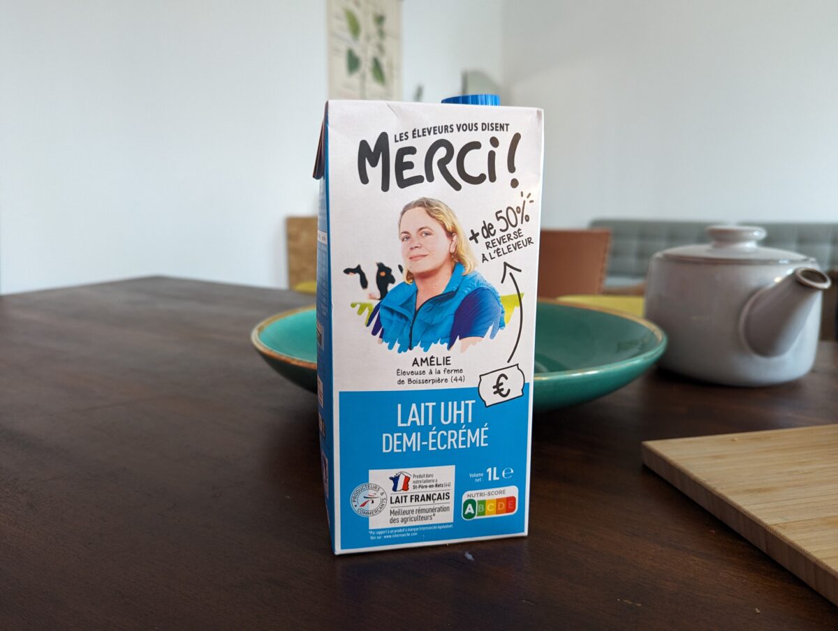 Photo d'une brique de lait de la marque "Les éleveurs vous disent merci !" où l'on voit le portrait d'Amélie, éleveuse.