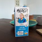 Photo d'une brique de lait de la marque "Les éleveurs vous disent merci !" où l'on voit le portrait d'Amélie, éleveuse.