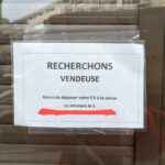 Petite annonce sur la vitrine d'un magasin où on lit "Recherchons vendeuse"