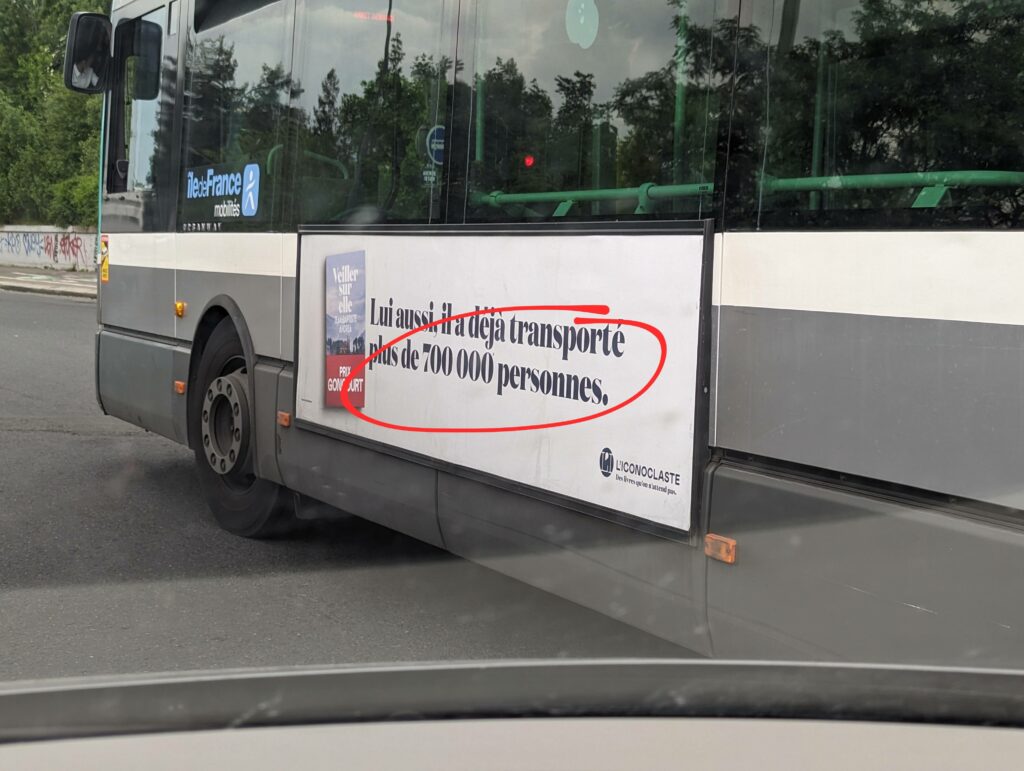 Publicité sur un bus pour le livre "Veiller sur elle" où on lit "Lui aussi, il a déjà transporté plus de 700 000 personnes"