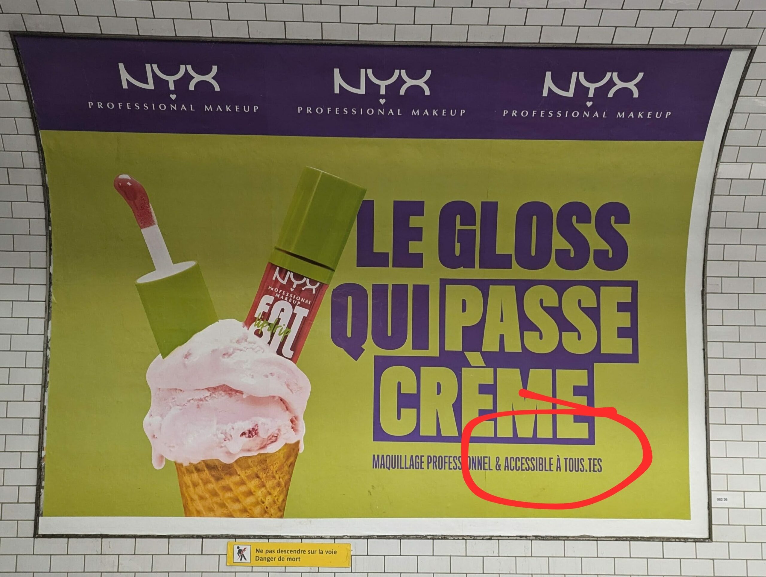 Affiche dans métro pour la marque de maquillage Nyx, on on voit le slogan "Le gloss qui passe crème. Maquilllage professionnel et accessible à tous.tes"