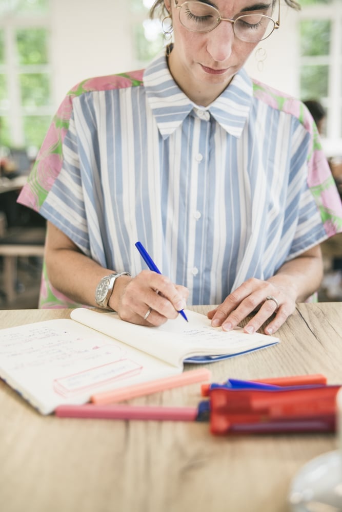 Alicia Birr en train d'écrire sur un cahier