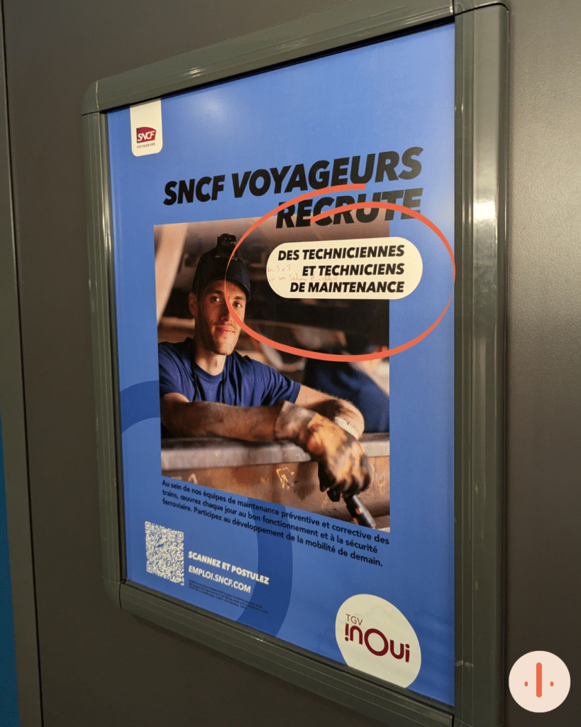 Une affiche de recrutement dans un train où on lit : SNCF Voyageurs recrute des techniciennes et techniciens de maintenance.